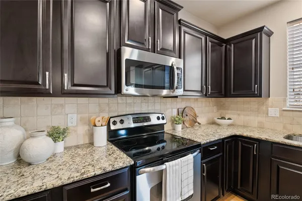a kitchen with granite countertop a sink stainless steel appliances and cabinets