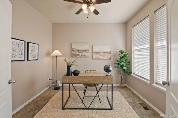 a view of a workspace with furniture and a window