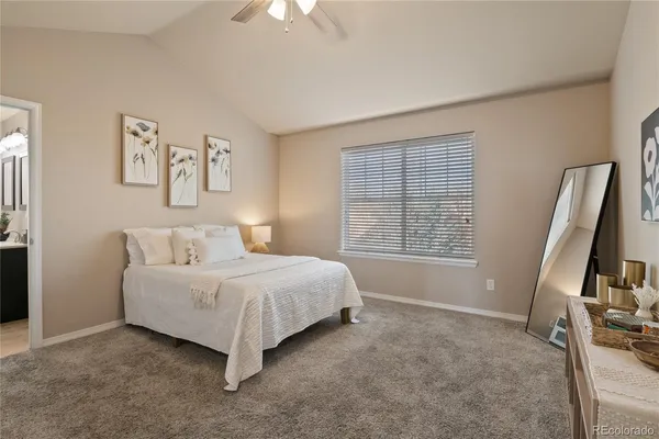 a spacious bedroom with a bed a couch and a window