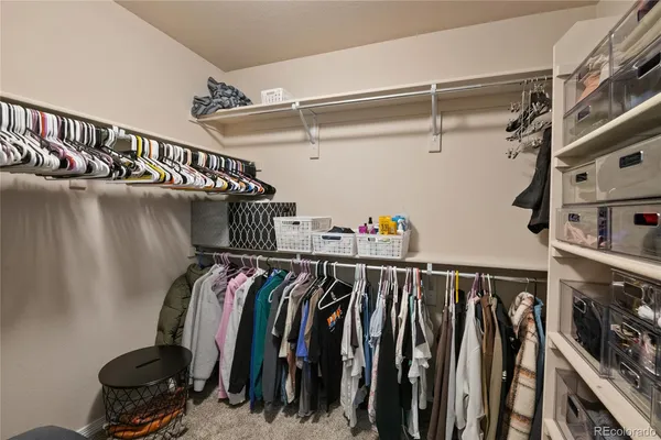 a view of walk in closet with clothes and shoes