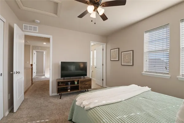 a bedroom with a bed and a flat tv screen on wall