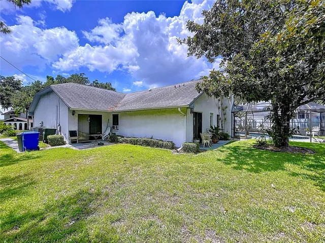 a view of an house with backyard and porch