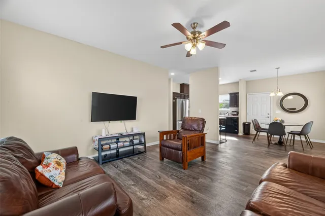 a living room with furniture and a flat screen tv with wooden floor