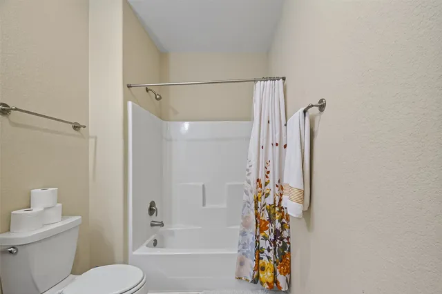 a bathroom with a shower a toilet and a shower