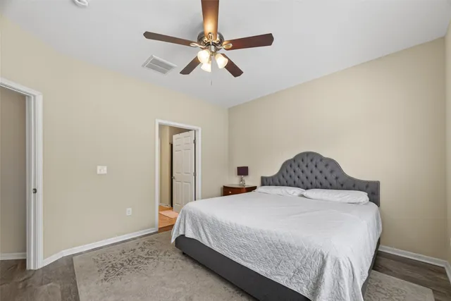 a bedroom with a bed and a ceiling fan