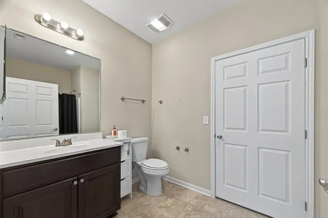 a bathroom with a double vanity sink a toilet and a mirror