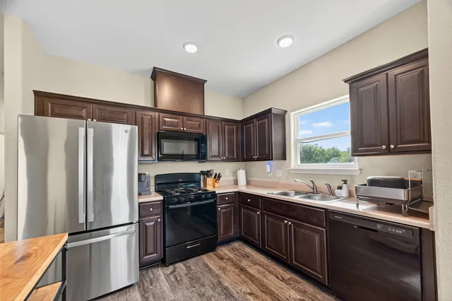 a kitchen with a refrigerator sink and wooden cabinets