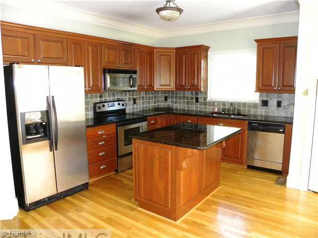 5909 A Ballinger Road Greensboro, NC 27410 - Photo 4 of 5 Kitchen. Kitchen has hardwoods, granite, tile backsplash! Open to Breakfast area!