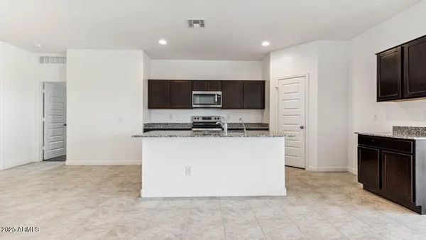 a kitchen with granite countertop a refrigerator and a stove top oven