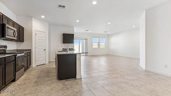 a kitchen with stainless steel appliances granite countertop a sink stove microwave and refrigerator