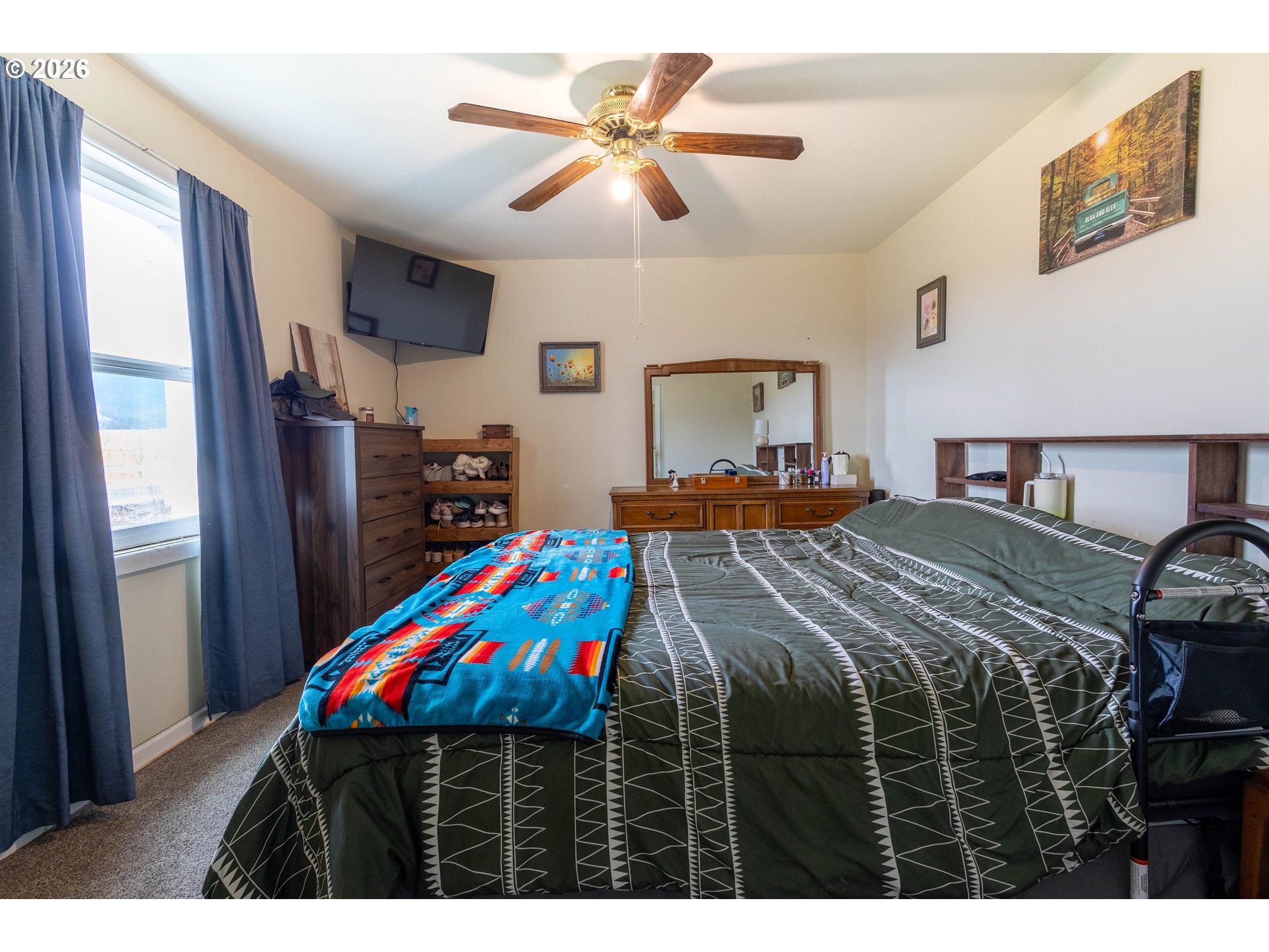 63150 Booth Lane La Grande, OR 97850 - Photo 14 of 29 a bedroom with a bed a dresser and a chandelier