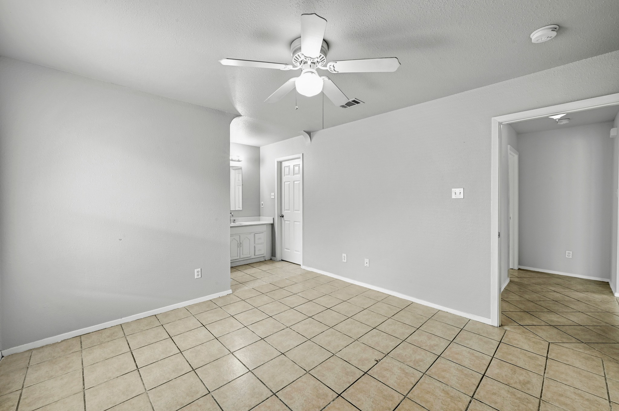 2212 Katy Lane Georgetown, TX 78626 - Photo 17 of 27 Interior room featuring neutral-toned tile flooring, light gray walls, and a ceiling fan with integrated lighting