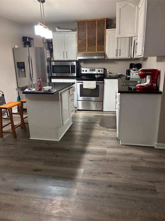 1528-1532 McFerrin Avenue Waco, TX 76708 - Photo 15 of 21 a kitchen with stainless steel appliances granite countertop a stove a sink dishwasher and a microwave oven with white cabinets