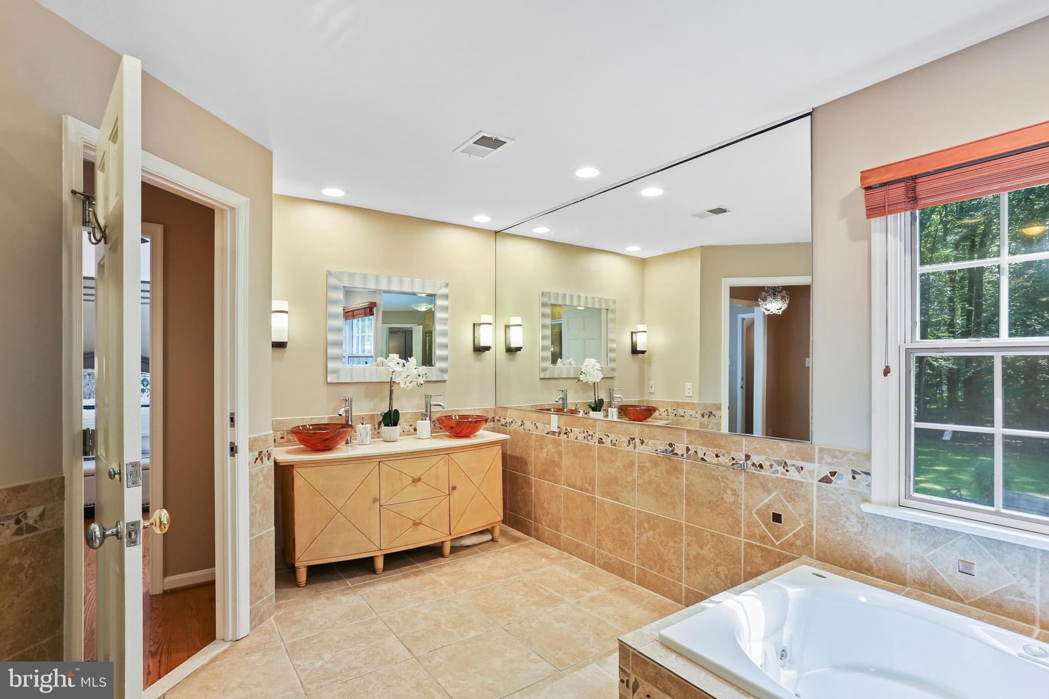 11843 Linden Chapel Road Clarksville, MD 21029 - Photo 45 of 128 a bathroom with a tub sink double vanity and mirror