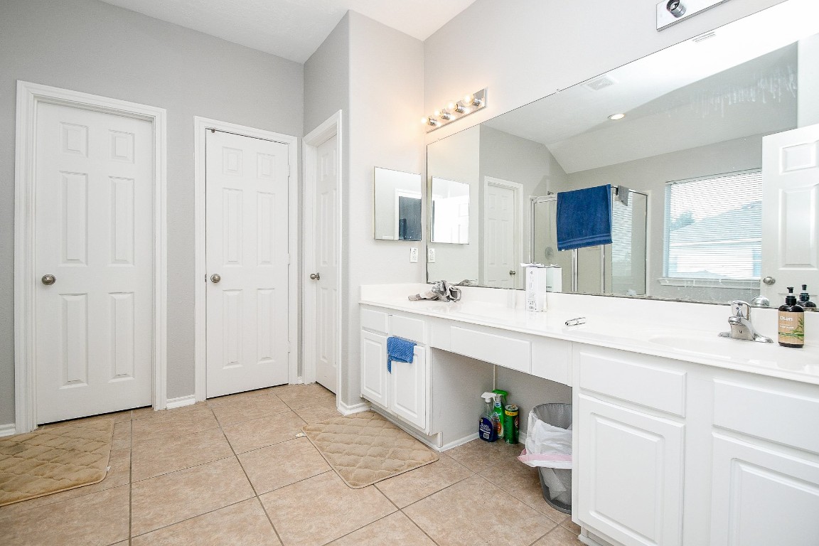 16402 Great Ridge Court Houston, TX 77083 - Photo 12 of 20 a spacious bathroom with a sink a mirror and a shower
