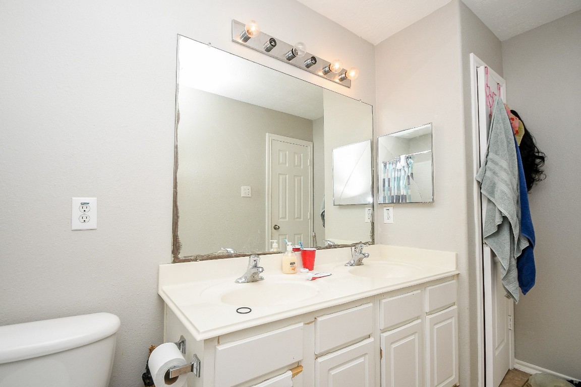 16402 Great Ridge Court Houston, TX 77083 - Photo 15 of 20 a bathroom with a sink a toilet and a mirror
