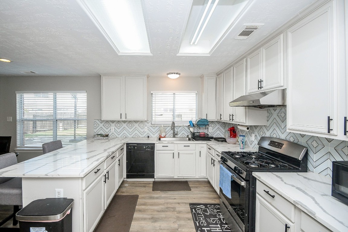 16402 Great Ridge Court Houston, TX 77083 - Photo 8 of 20 a kitchen with a sink stove top oven and cabinets
