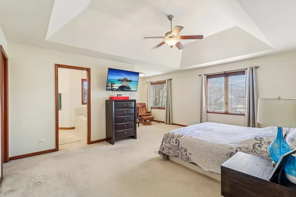 a spacious bedroom with a bed and a chandelier