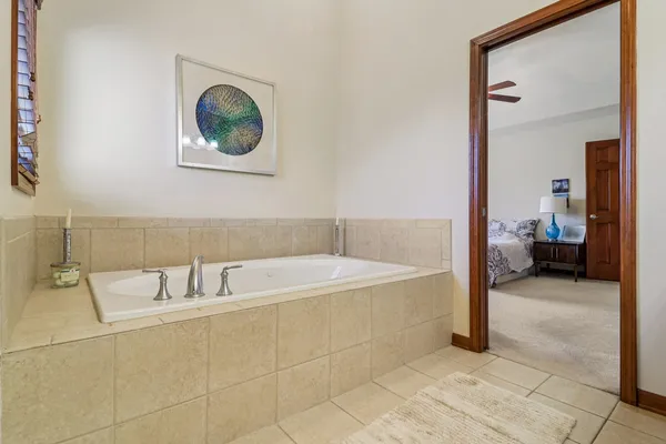 a spacious bathroom with a tub and a mirror