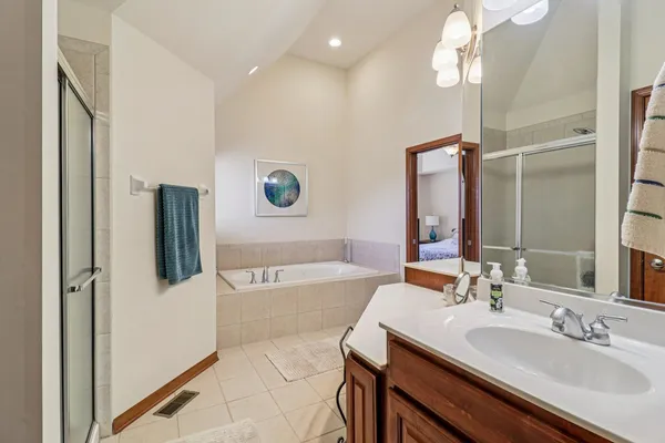 a bathroom with a tub sink and mirror