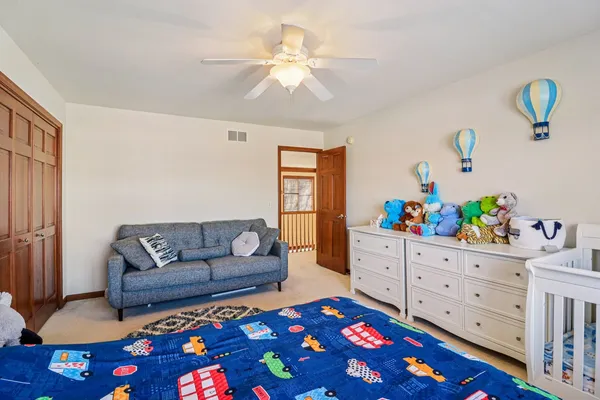 a living room with furniture and a baby crib