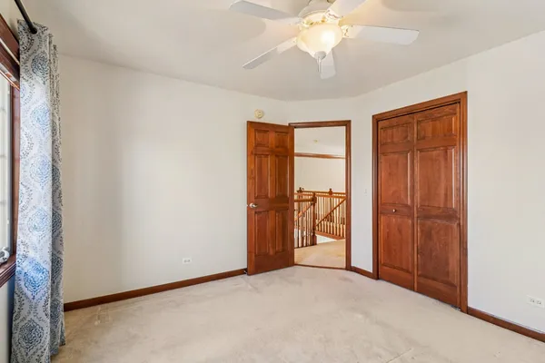 an empty room with closet and chandelier fan