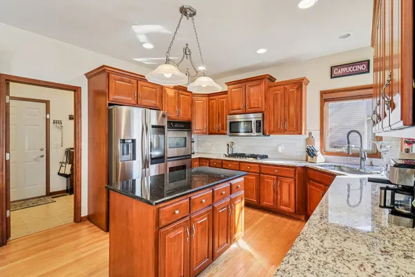 a kitchen with stainless steel appliances granite countertop a sink refrigerator and cabinets