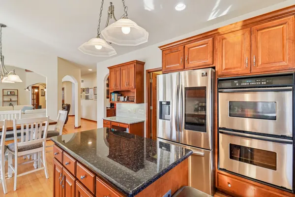 a kitchen with stainless steel appliances granite countertop a stove refrigerator and cabinets