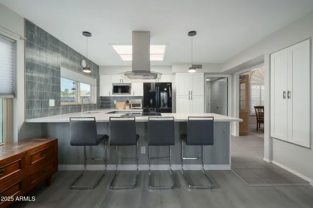 a kitchen with kitchen island granite countertop a table and chairs in it