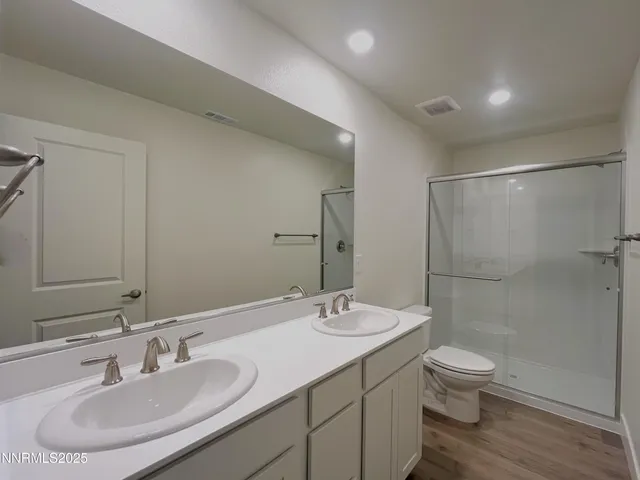 a bathroom with a double vanity sink toilet and shower