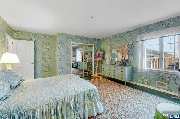 a bedroom with a bed mirror and window