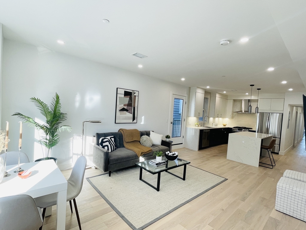 106 Webster Street, Unit 201 Boston, MA 02128 - Photo 1 of 33 a living room with furniture kitchen view and a table