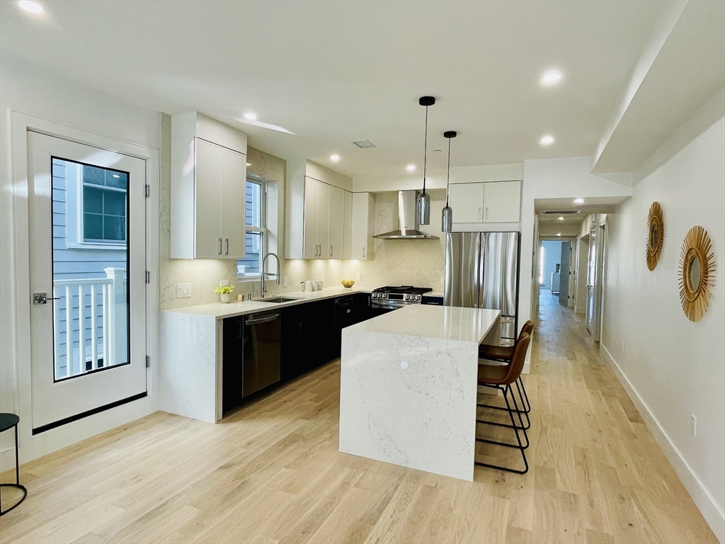 106 Webster Street, Unit 201 Boston, MA 02128 - Photo 2 of 33 a kitchen with a sink cabinets and wooden floor