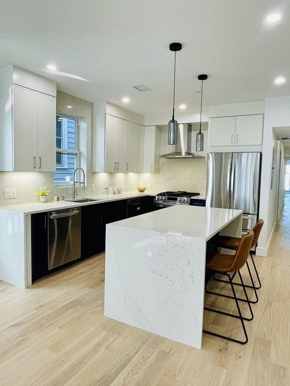 106 Webster Street, Unit 201 Boston, MA 02128 - Photo 4 of 33 a kitchen with stainless steel appliances a sink a stove a refrigerator and island
