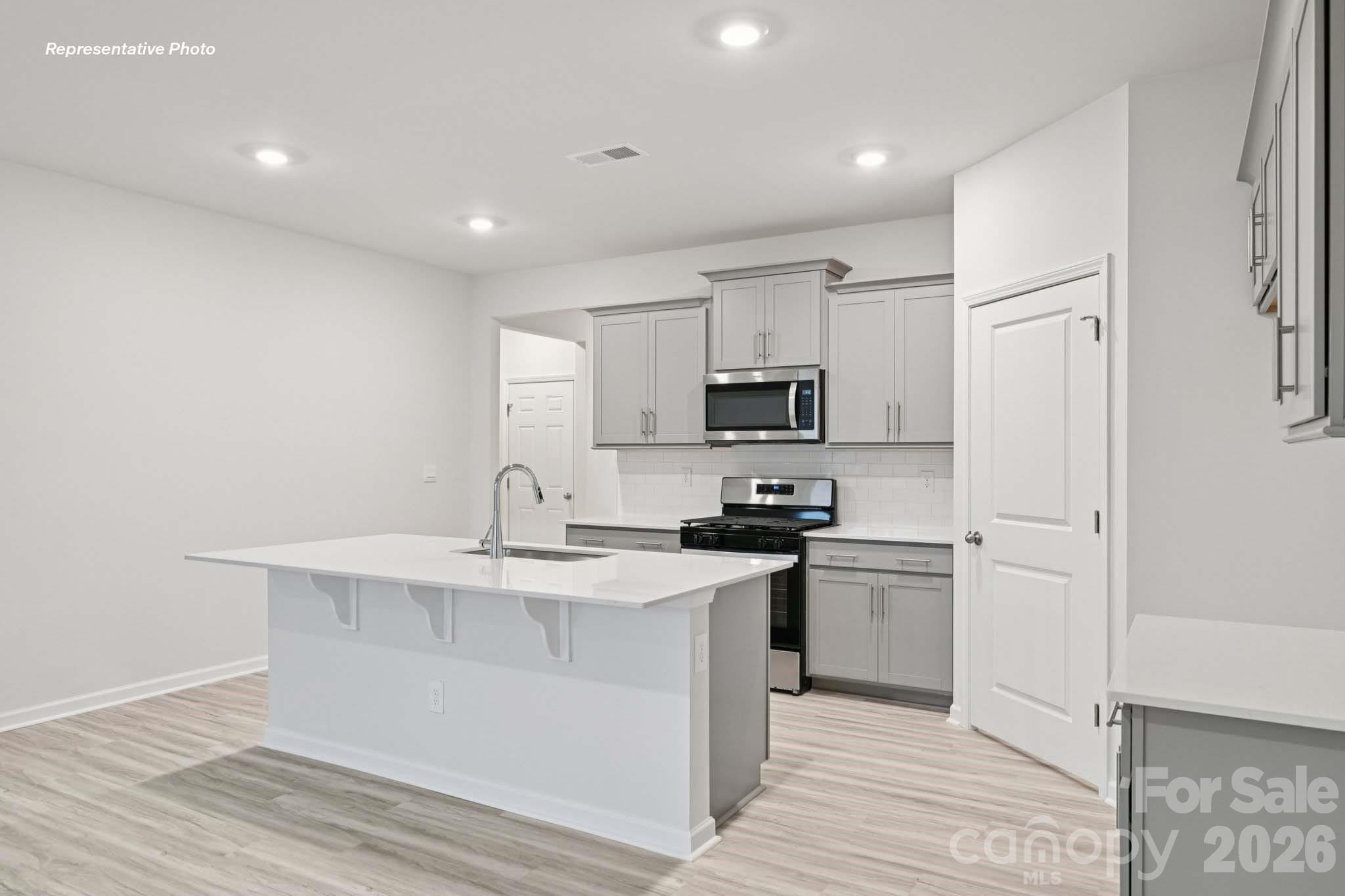7881 Old Brk Road Sherrills Ford, NC 28673 - Photo 10 of 26 a kitchen with stainless steel appliances a white stove top oven and white cabinets