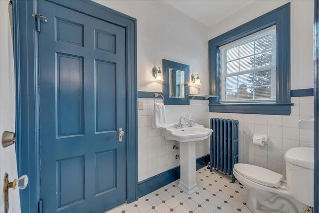 a bathroom with a toilet sink and mirror
