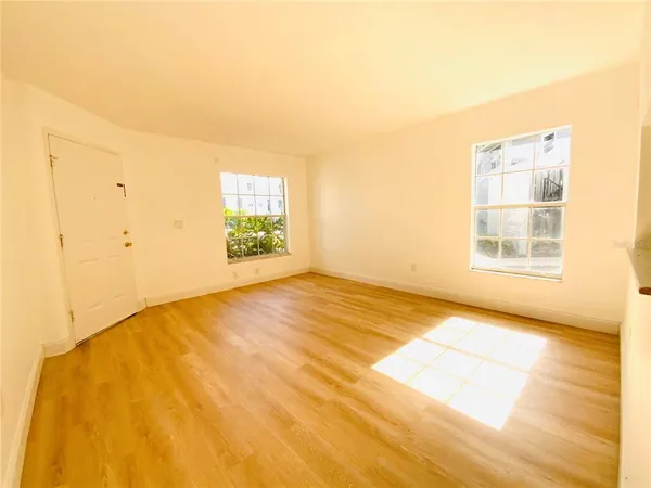 a view of an empty room with wooden floor