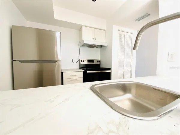a kitchen with a sink and a refrigerator