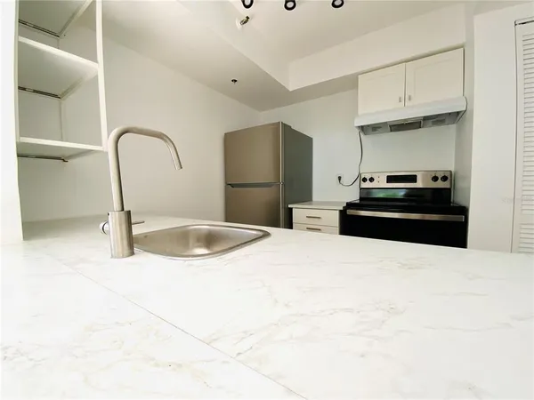 a kitchen with granite countertop a refrigerator and a stove
