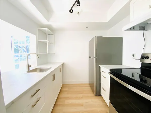 a kitchen with granite countertop a sink and a refrigerator