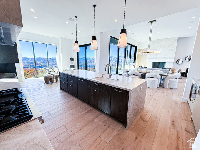 2132 East Outlaw Road, Unit 49 Kamas, UT 84036 - Photo 44 of 44 Kitchen with open floor plan, decorative light fixtures, light stone counters, light wood-style flooring, and a center island with sink