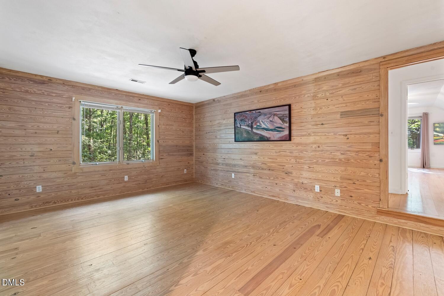 7391 Howerton Road Elon, NC 27244 - Photo 39 of 53 Wood-paneled walls and wood-finish flooring with a ceiling fan and window