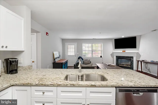 a kitchen with granite countertop a sink and a stove top oven with wooden floor