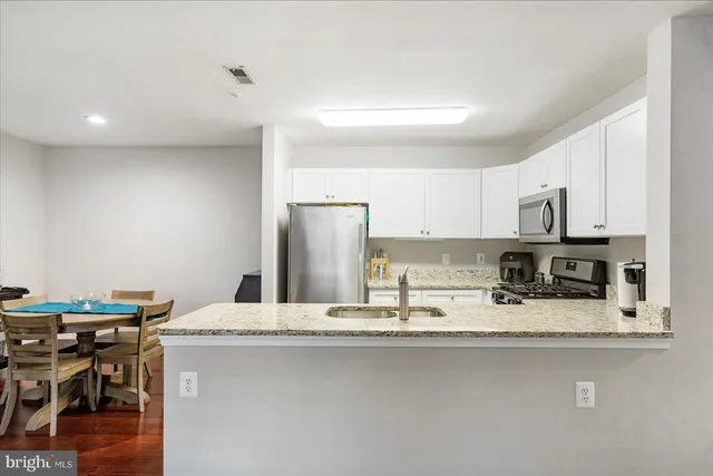 a kitchen with stainless steel appliances granite countertop a sink and a refrigerator