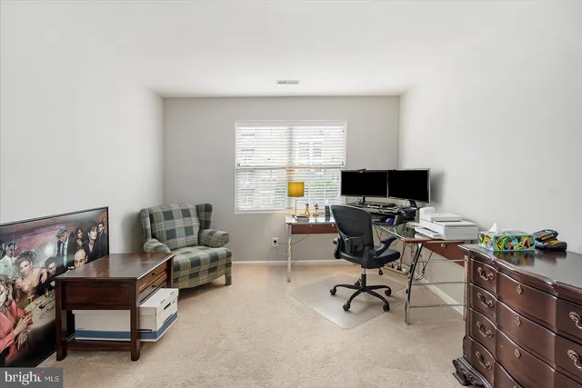 a view of a workspace with furniture and a window