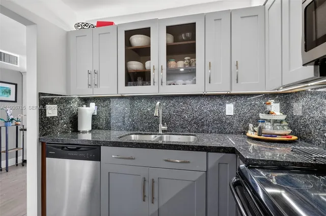 a kitchen with stainless steel appliances granite countertop a sink stove and microwave