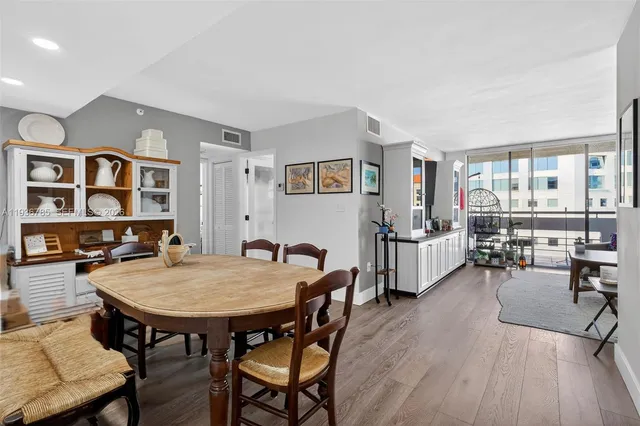 a dining room with wooden floor and large windows