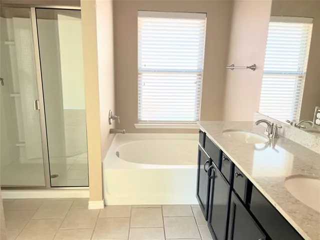 a bathroom with a tub sink and mirror