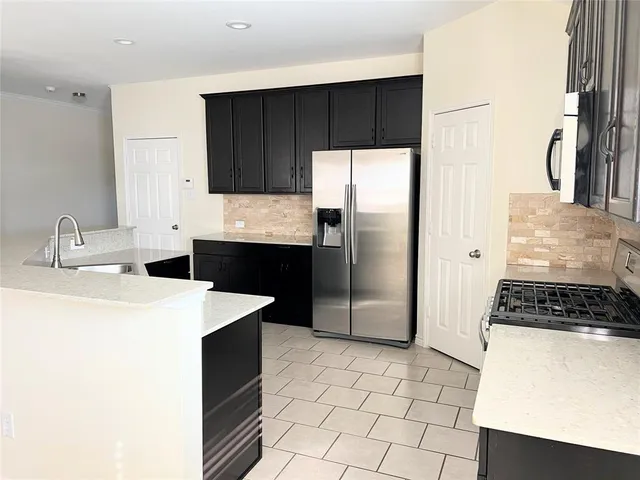 a kitchen with a sink a refrigerator and a stove