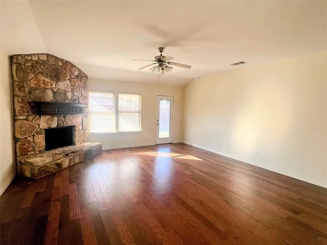 wooden floor in an empty room with a fireplace